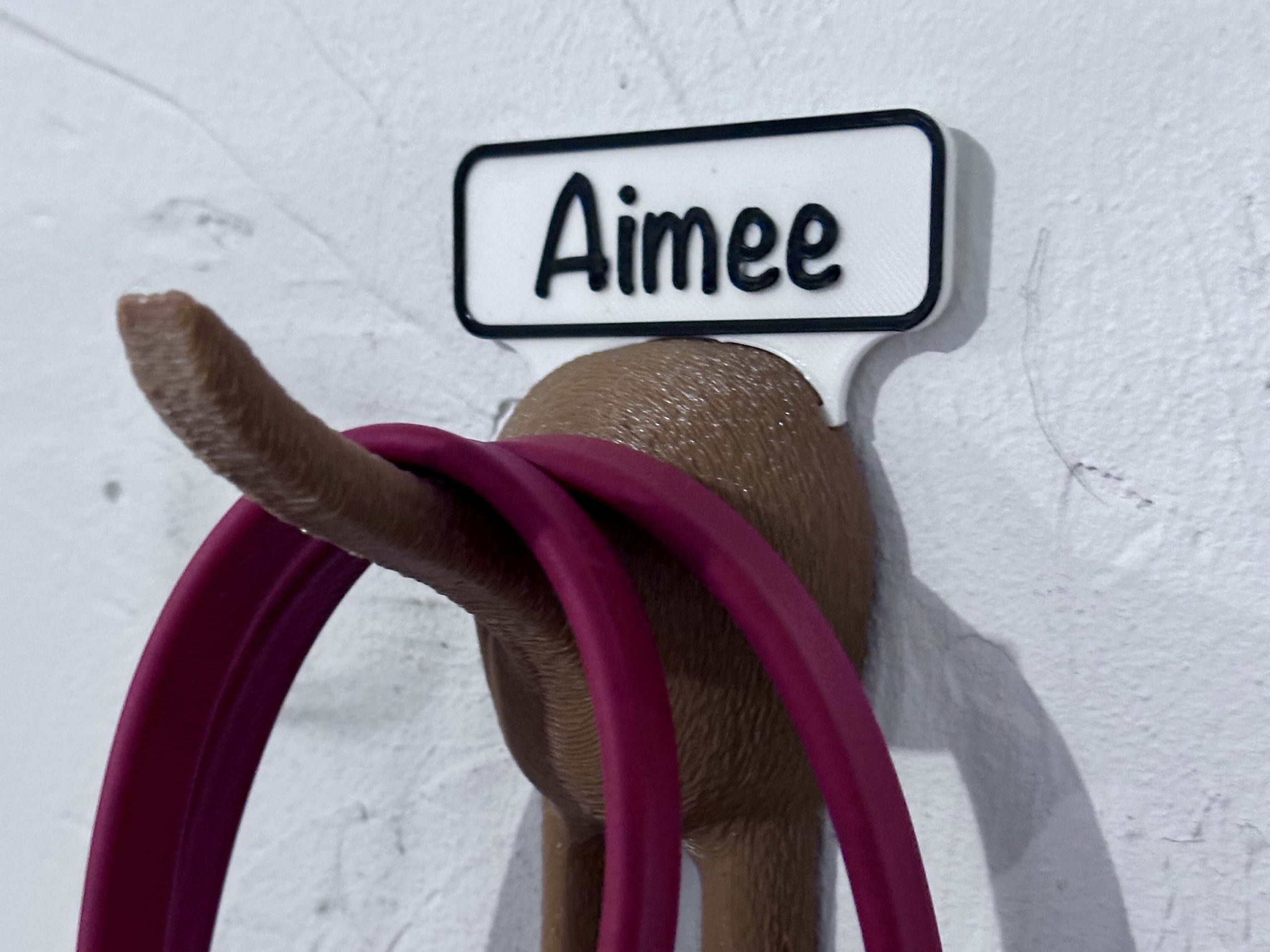 Wall mounted leash hanger shaped like a dog tail and a dog's behind